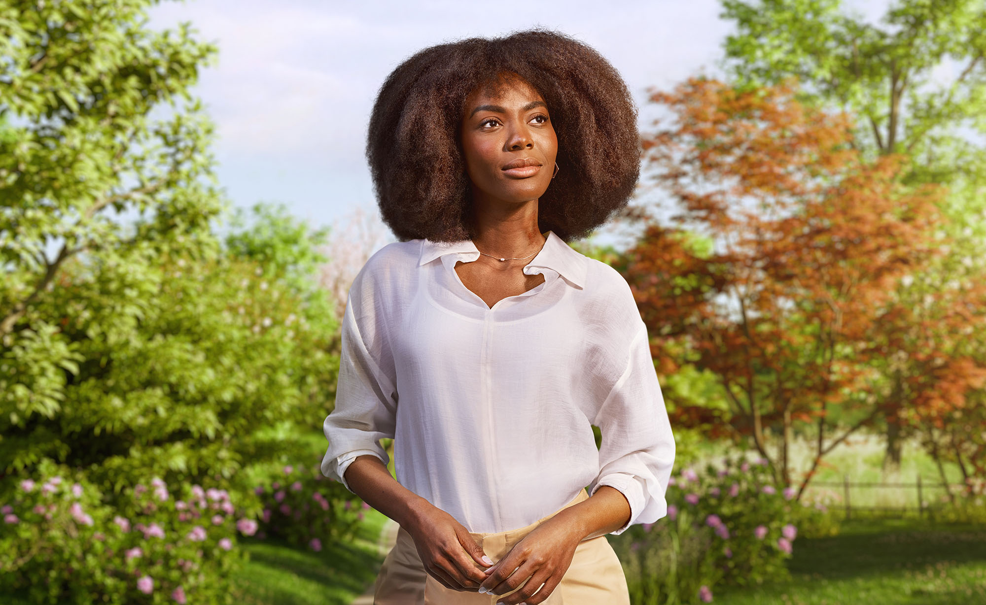 Woman standing in a park surrounded by trees